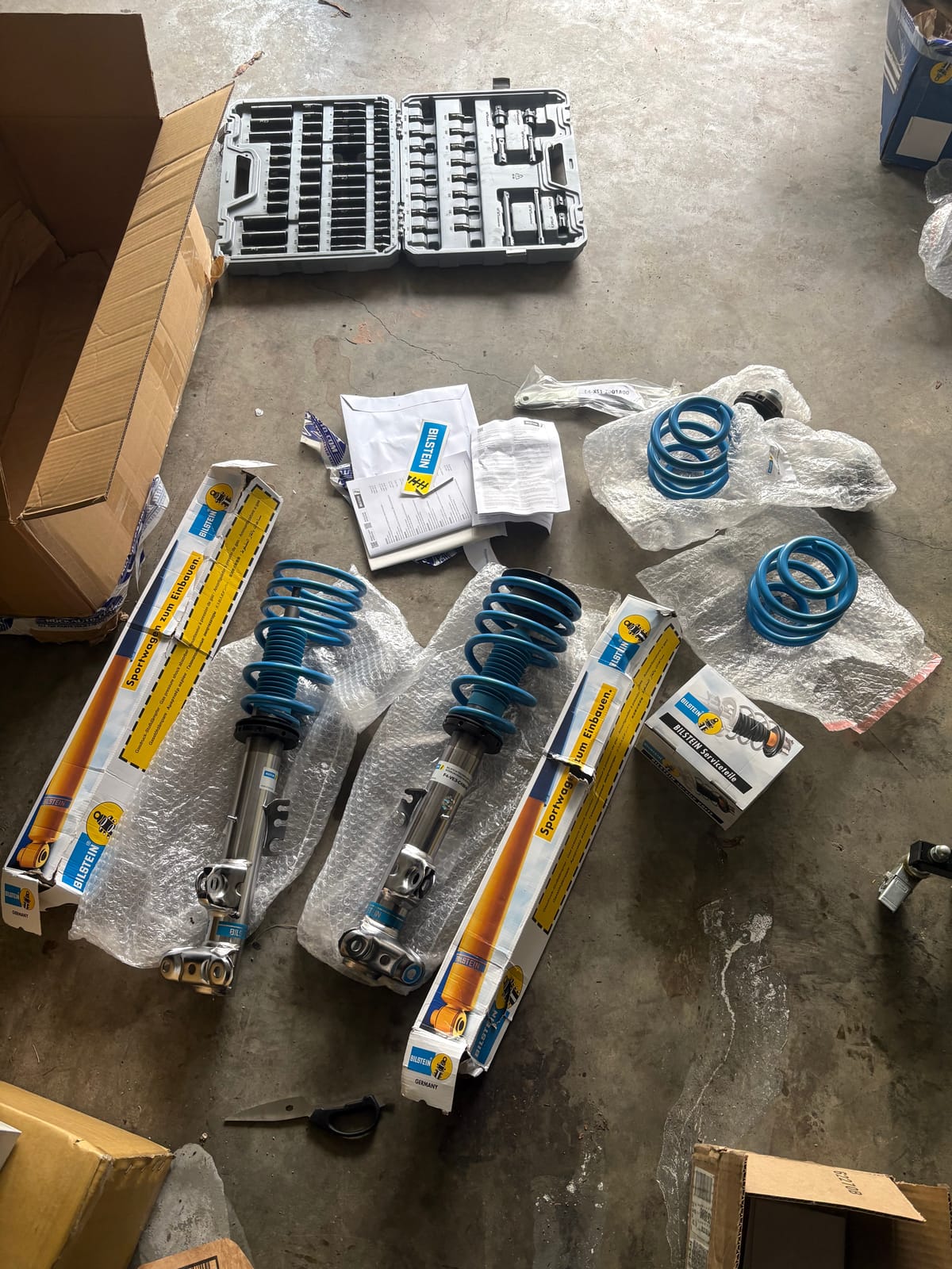 Bilstein coilover kit unboxed and laid out in the garage