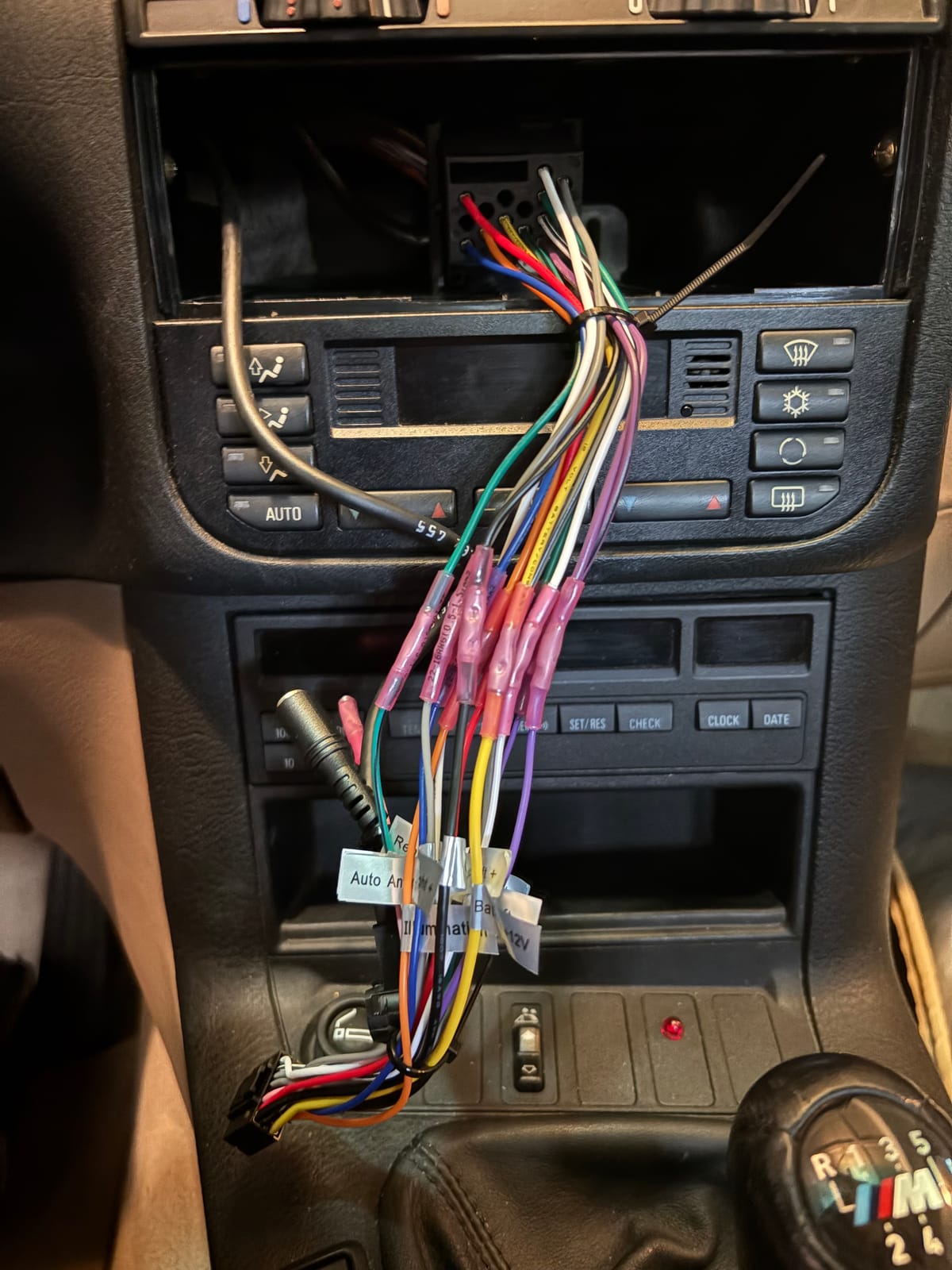 Aftermarket head unit wiring harness spliced into the factory BMW dash wiring