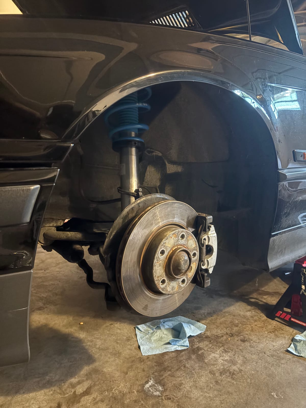 Front hub, brake caliper, and new Bilstein spring during suspension install
